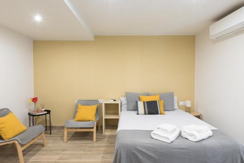 a bedroom with two beds and two chairs at Hostal Oliveta in Barcelona