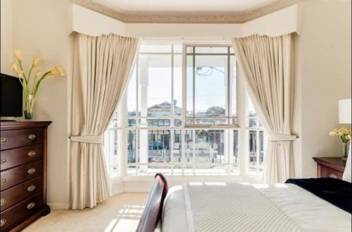 メルボルンにあるCosy private room easy access to city & airportのベッドルーム1室(ベッド1台、大きな窓付)