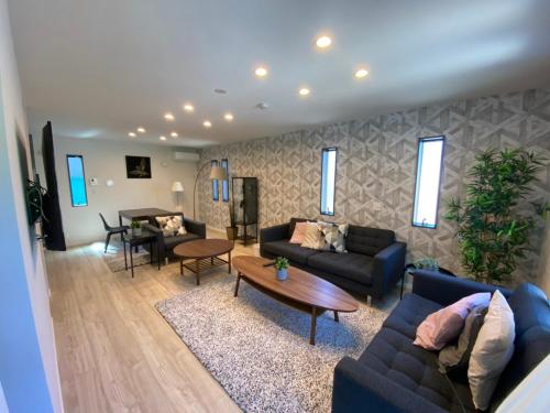 a living room with two couches and a table at Enalee Beach Villa in Kanayama