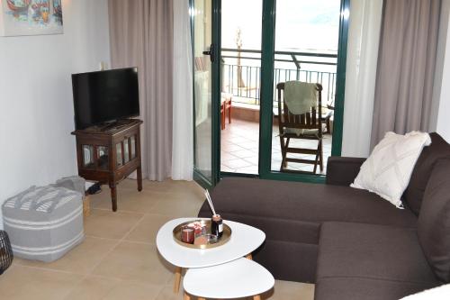 a living room with a couch and a tv at Port Balchik apartment in Balchik