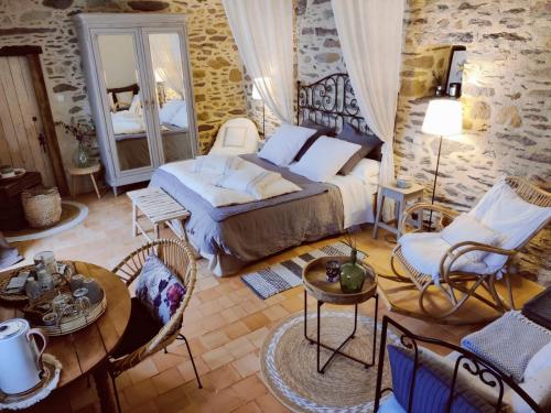1 dormitorio con 1 cama, mesa y sillas en Manoir le Courtillon en Le Pont Réan