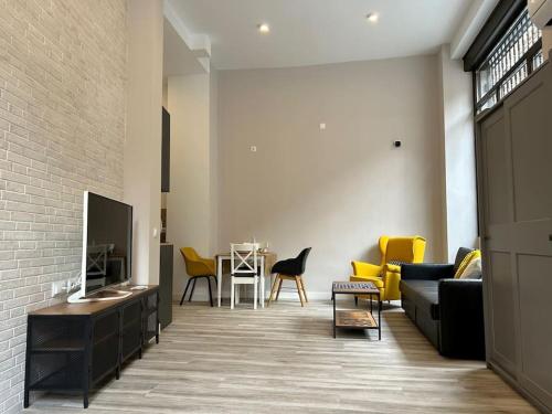 un soggiorno con divano e tavolo con sedie di Estudio céntrico zona palacio a Madrid