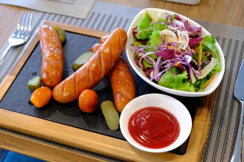 a tray with carrots and a salad and a bowl of sauce at FLC City Hotel Beach Quy Nhon in Quy Nhon