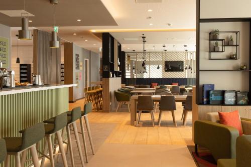 ein Restaurant mit einer Bar sowie Tischen und Stühlen in der Unterkunft Holiday Inn - Eindhoven Airport, an IHG Hotel in Eindhoven