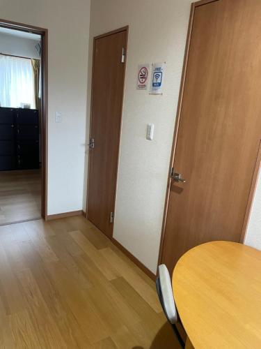 a room with a table and a door and a table and chairs at Karin doo Hotel in Narita