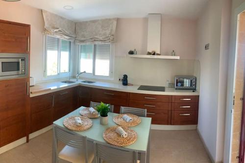 a kitchen with a table and some chairs and a counter at Villa Gloria in Los López
