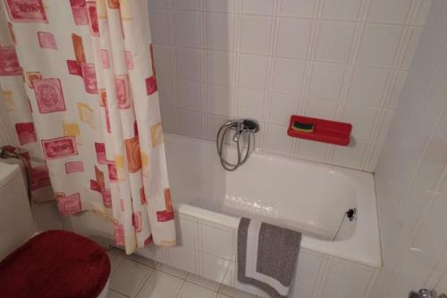 ein Bad mit einer Badewanne und einem Duschvorhang in der Unterkunft Eretria vacation house in Eretria