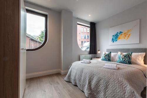 a bedroom with a bed and two windows at Apartment Six Staines Upon Thames - Free Parking - Heathrow - Thorpe Park in Staines