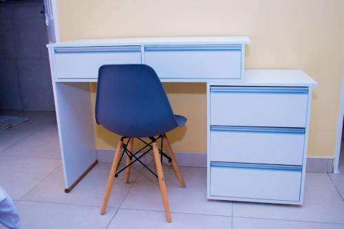 a desk with a blue chair and a desk with drawers at Home@Amalia’s in Rundu
