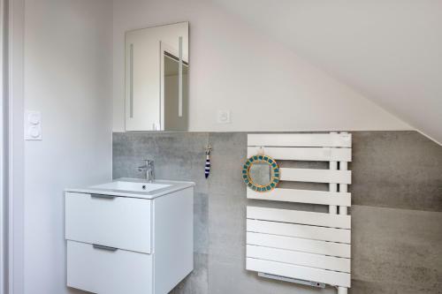ein weißes Badezimmer mit einem Waschbecken und einer Treppe in der Unterkunft Calme, detente et modernite a Sarzeau in Sarzeau
