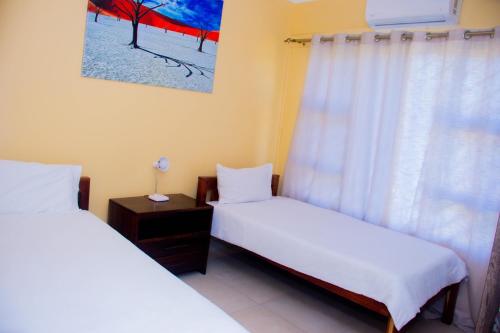 two twin beds in a room with a window at Home@Amalia’s in Rundu