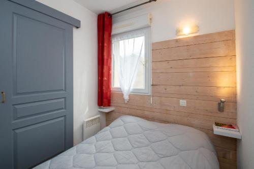 a bedroom with a bed and a window at Balnearia - Appt avec piscine partagée in Montauban-de-Luchon