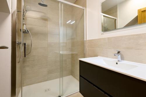 a bathroom with a glass shower and a sink at Le Noyer - Appt avec terrasse et jardin partagé in Puberg