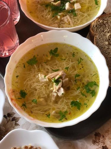 a bowl of chicken noodle soup on a table at Катерина in Chynadiyovo