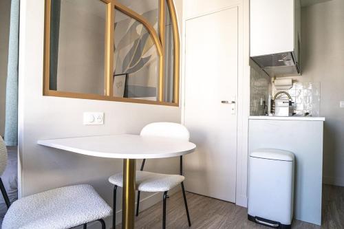 eine kleine Küche mit einem weißen Tisch und zwei Hockern in der Unterkunft Bright 20m near the Eiffel Tower in Paris