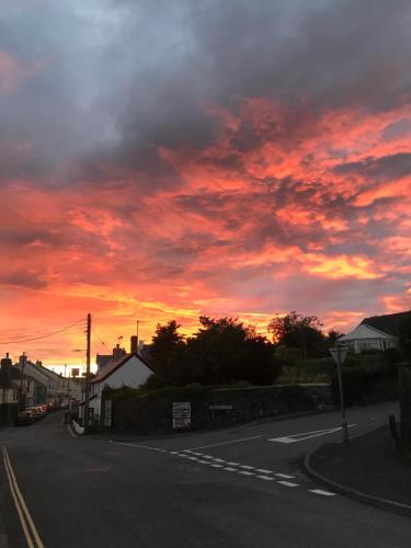 an empty street with a sunset in the sky at Unfurnished Bell Tent close to SWC path in Hartland