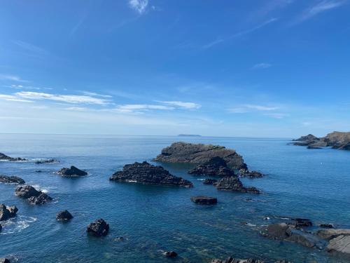 an island in the ocean with rocks in the water at Unfurnished Bell Tent close to SWC path in Hartland