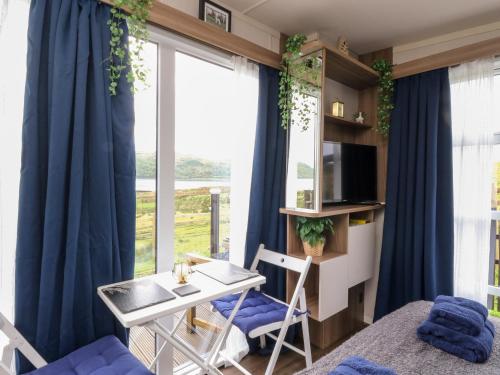 Zimmer mit einem Tisch, Stühlen und einem Fenster in der Unterkunft Balvicar Beag in Oban