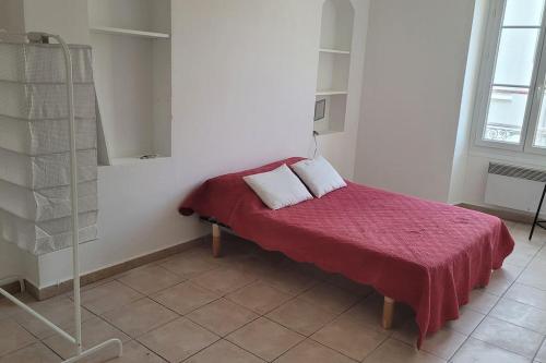 a bedroom with a bed with a red blanket and two pillows at Appartement Toulon 5/6 couchages in Toulon