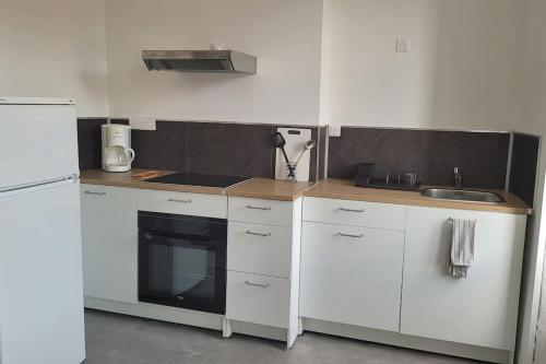 a small kitchen with white cabinets and a sink at Appartement Toulon 5/6 couchages in Toulon
