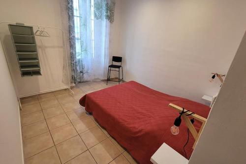 a bedroom with a red bed and a chair at Appartement Toulon 5/6 couchages in Toulon