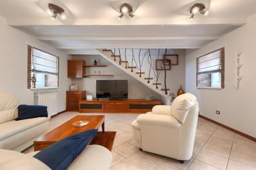 a living room with white furniture and a staircase at Villa Mala in Umag