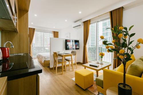 - un salon avec un canapé jaune et une table dans l'établissement The Euphoria Hanoi - STAY 24h, à Hanoï