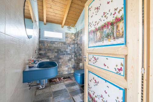 Il Campo di Nonno Giò في سبوليتو: حمام مع حوض أزرق ومرحاض
