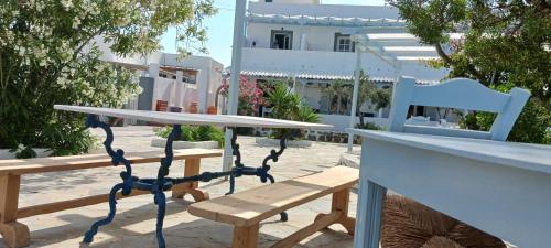 a picnic table and benches in front of a building at Elia in Skala