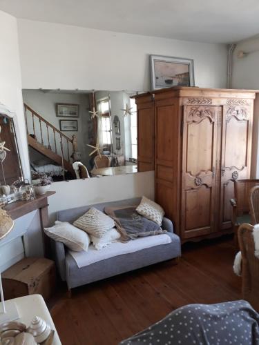 - un salon avec un canapé et une armoire en bois dans l'établissement le corps de garde du Crotoy, au Crotoy