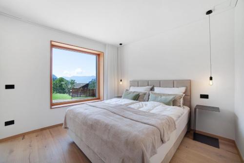 um quarto branco com uma cama grande e uma janela em Alivo Living Apartment Olivia em Rifiano