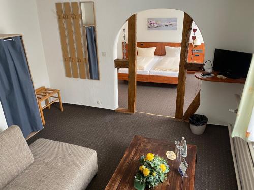 een woonkamer met een bank en een bed bij Hotel Pension Gelpkes Mühle in Bad Sachsa