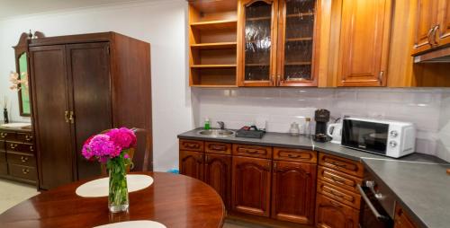 a kitchen with a table with a vase of flowers on it at OPERA16 Guestrooms in Budapest