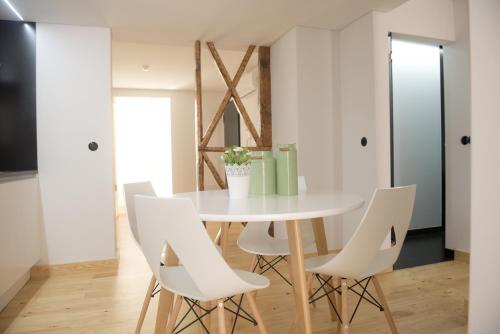 a dining room with a white table and white chairs at Páteo Saudade Lofts in Lisbon