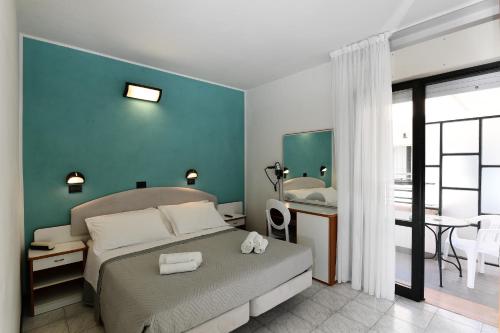 リミニにあるHotel Criniera D'oroのベッドルーム1室(ベッド1台、テーブル付)、バスルーム1室が備わります。
