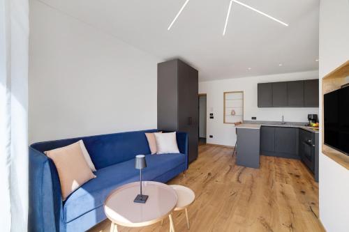 a living room with a blue couch and a table at Alivo Living Apartment Aurora in Rifiano
