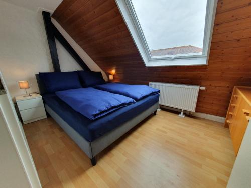 una camera da letto con letto blu in mansarda di Gemütliche zentrale DG Wohnung in Mühlacker a Mühlacker