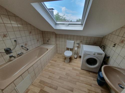 a bathroom with a tub and a toilet and a sink at Gemütliche zentrale DG Wohnung in Mühlacker in Mühlacker