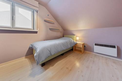 - une petite chambre avec un lit et une fenêtre dans l'établissement Gezellige woning in Oostnieuwkerke, à Staden