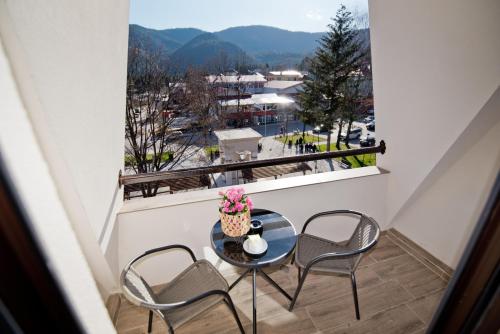 a table and chairs on a balcony with a view at СПА Хотел Романтика in Sarnitsa