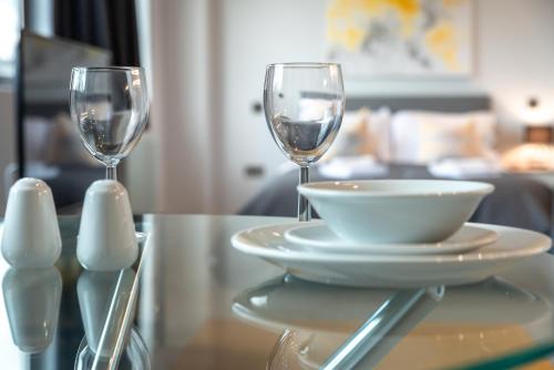Dois copos de vinho e uma taça na mesa. em Apartment Twenty Three Staines Upon Thames - Free Parking - Heathrow - Thorpe Park em Staines