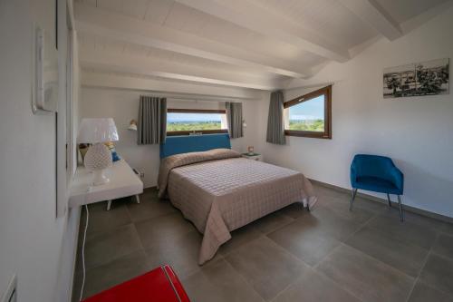 a bedroom with a bed and a table and a blue chair at Villa Carmiano Luxury bedrooms in Avola in the province of Syracuse with room with swimming pool in Avola