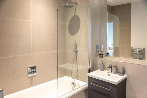 uma casa de banho com um chuveiro e um lavatório. em Apartment Twenty Three Staines Upon Thames - Free Parking - Heathrow - Thorpe Park em Staines