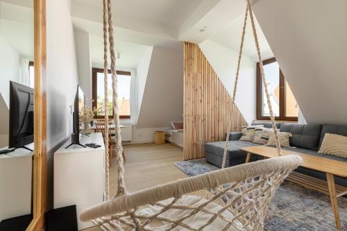 a living room with a swing and a couch at Homewell Apartments Wilson Park II in Poznań