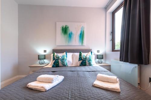 a bedroom with a large bed with two pillows at Apartment Fourteen Staines Upon Thames - Free Parking - Heathrow - Thorpe Park in Staines