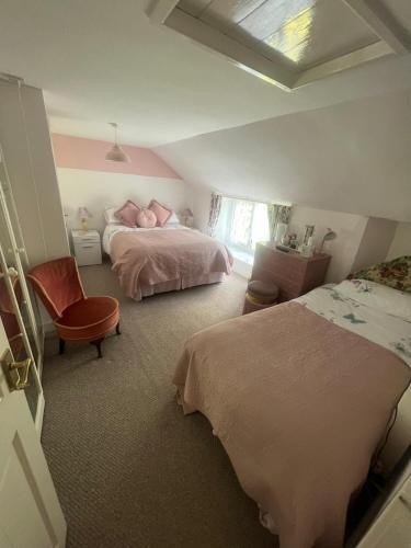 a bedroom with two beds and a chair at Broadmoor Farm in Kilgetty
