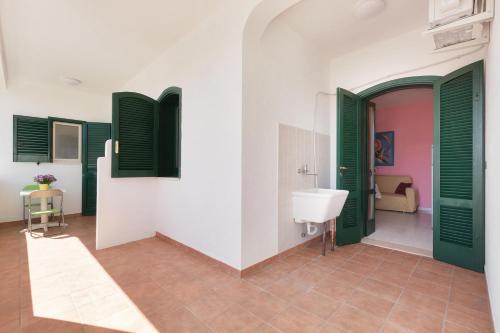 a bathroom with green and white walls and a sink at Dima Apartments by BarbarHouse in San Foca