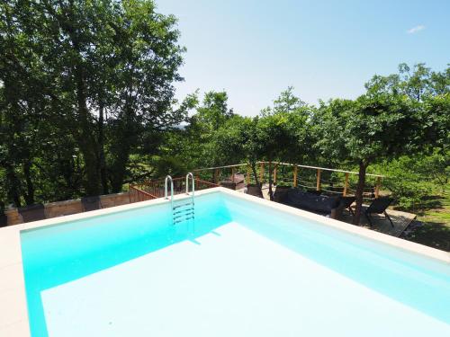 une piscine bleue avec des arbres en arrière-plan dans l'établissement Magnifique Villa de prestige, piscine chauffée, à Marnac