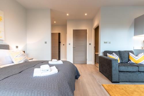 a bedroom with a large bed and a couch at Apartment Thirty One Staines Upon Thames - Free Parking - Heathrow - Thorpe Park in Staines