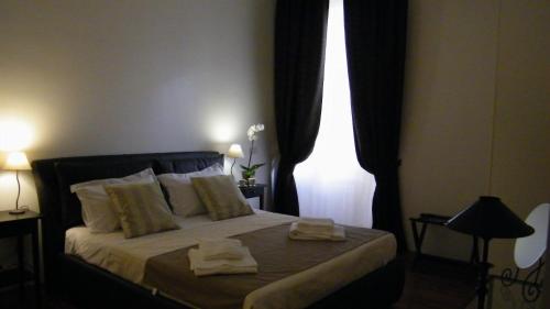 ローマにあるLa Tua Casa al Colosseoのベッドルーム1室(ベッド1台、タオル2枚付)